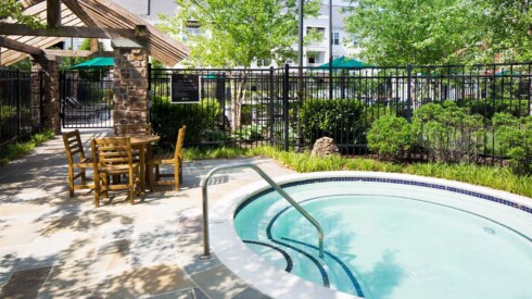 Outdoor hot tub with walkway to main pool behind City Center Townes