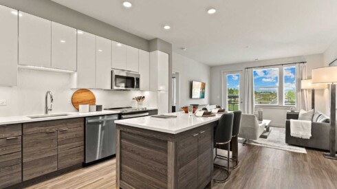 Open concept kitchen with hardwood floors, island, and modern appliances