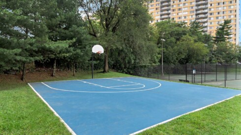 Community basketball court behind main Excelsior Tower building
