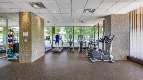 Fitness center view of equipment with man running on treadmill