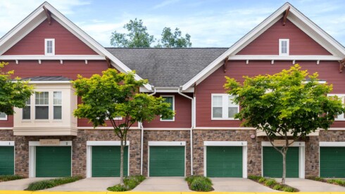 Buildings with a deep red exterior and green garage doors
