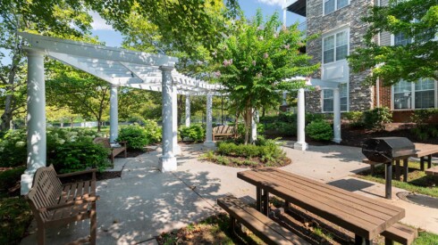 Exterior courtyard with grill and benches at the Remington apartments