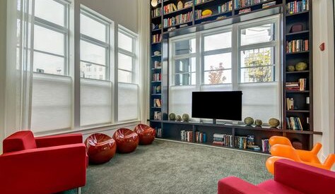 Lobby with bookshelf and TV at Windmill Parc apartments