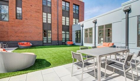 Outdoor courtyard seating and turf area at the Windmill Parc apartments